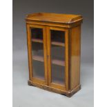 An oak book case, late 19th/early 20th century, with gallery top, above two glazed doors enclosing