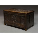 A large oak coffer, late 17th century, profusely carved throughout with foliate scrolls, on simple