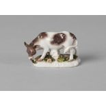 A Continental porcelain model of a cow, 18th century, on a naturally modelled pad base,