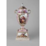 A Vienna style Dresden urn, late 19th/early 20th century, the lid with bird and leaf finial,