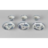 A set of three English porcelain tea bowls and saucers, 18th century, painted with floral sprays,