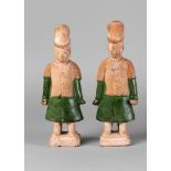 A pair of Chinese pottery attendant figures, Ming dynasty, modelled standing,