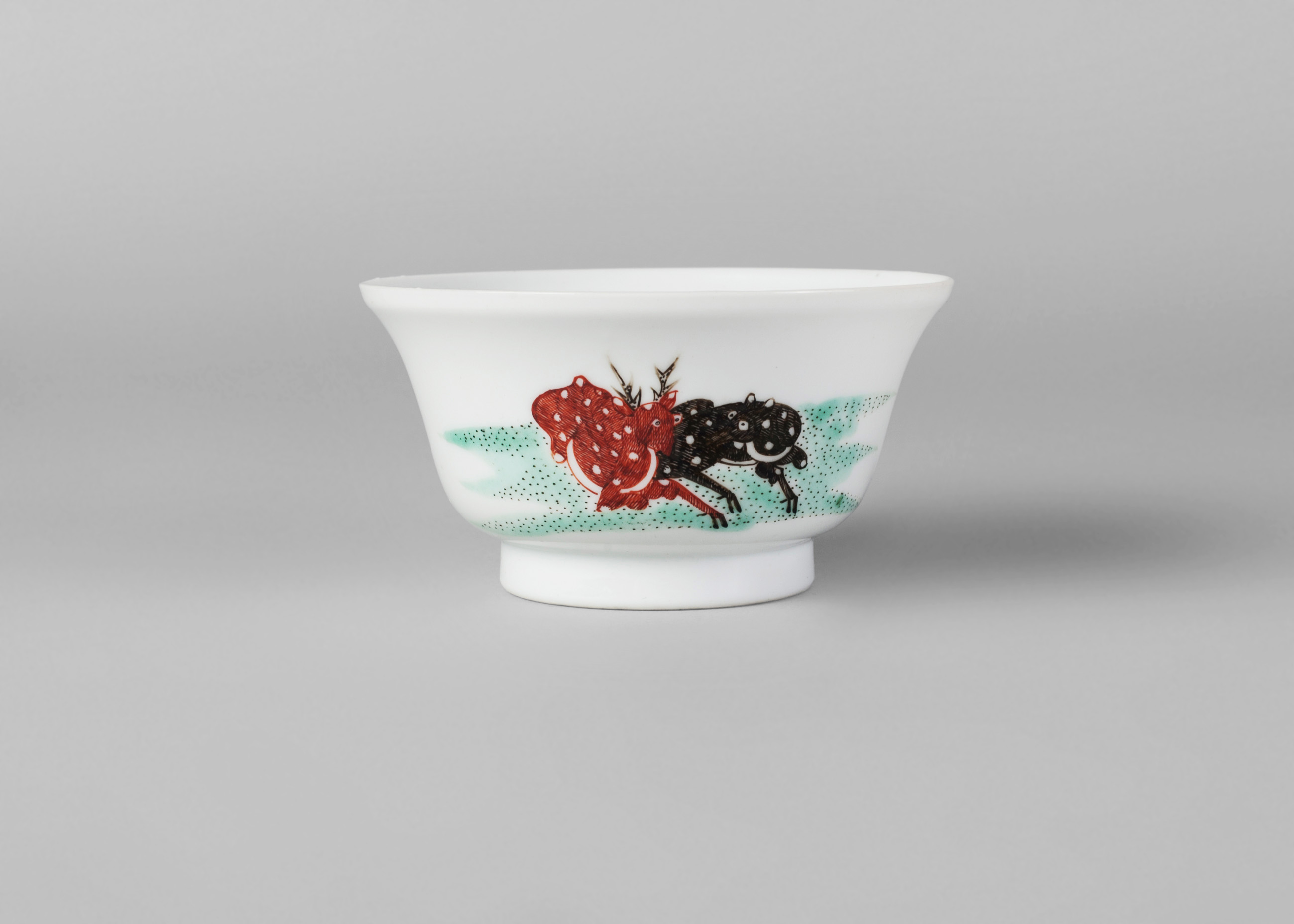 A Chinese porcelain bowl, late Qing dynasty, painted in enamels with two recumbent deer,