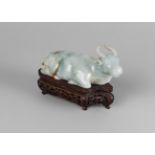 A Chinese jadeite buffalo, early 20th century, carved in recumbent pose,