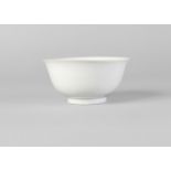 A Chinese porcelain bowl, Qianlong mark and of the period, of ogee form and with plain white glaze,