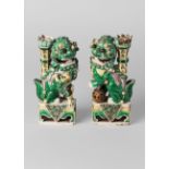 A pair of Chinese biscuit porcelain sancai Buddhist lion incense holders, Qing dynasty,