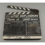 A film clapper board, late 20th century, titled for the Little Shop of Horrors with details of the