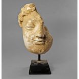 A Gandharan fragmentary stucco head of a Buddha, modelled with curly hair,