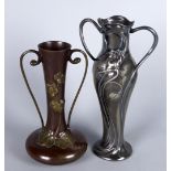 A WMF pewter twin handled vase, moulded with iris flowers, impressed marks to base, lacking liner,