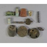 A collection of twelve various amulets, to comprise an animal form model of an ox, two buttons,