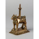 A brass votive candlestick in the form of Nandi , India, 19th century, raised on a stepped base,