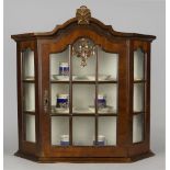 A walnut wall cabinet, mid/late 20th century, with arched top and glazed door and sides,