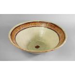 A large Samanid slip-painted pottery bowl, Iran, 10th century, of conical form on a short foot,