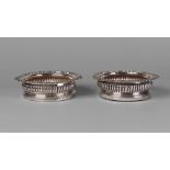 Of horse racing interest: A matched pair of George IV silver and turned wood bottle coasters,