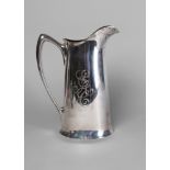 A large five pint American Sterling silver jug, of oval form, with elaborate engraved monogram,