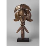 A Kota metal and hardwood carved reliquary guardian figure, wearing a crested head piece,