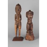 A fragmentary hardwood tribal figure of a man holding a pipe, Ivory Coast, mounted on a stand,