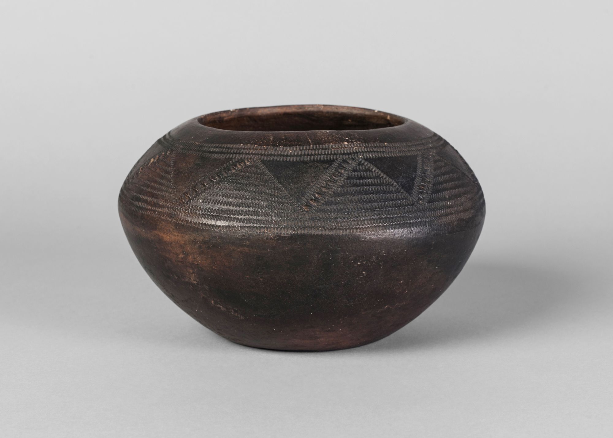 A Bulu pottery globular pottery bowl, incised with geometrical decoration,