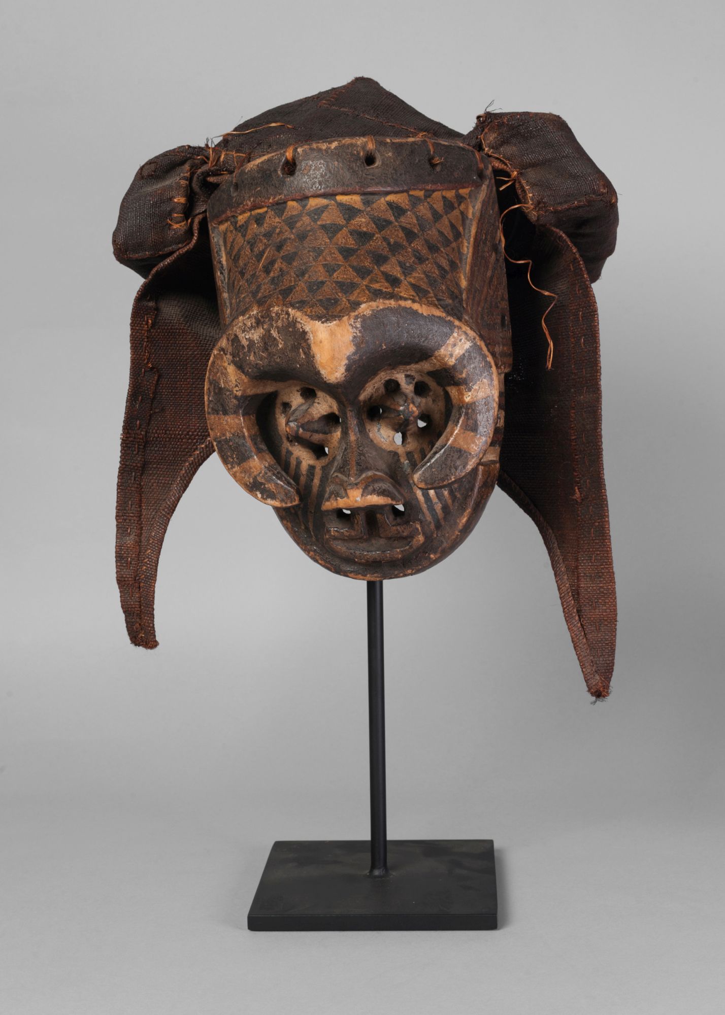 A Kuba tribal mask, of carved wooden form with a heavy brow,