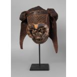 A Kuba tribal mask, of carved wooden form with a heavy brow,