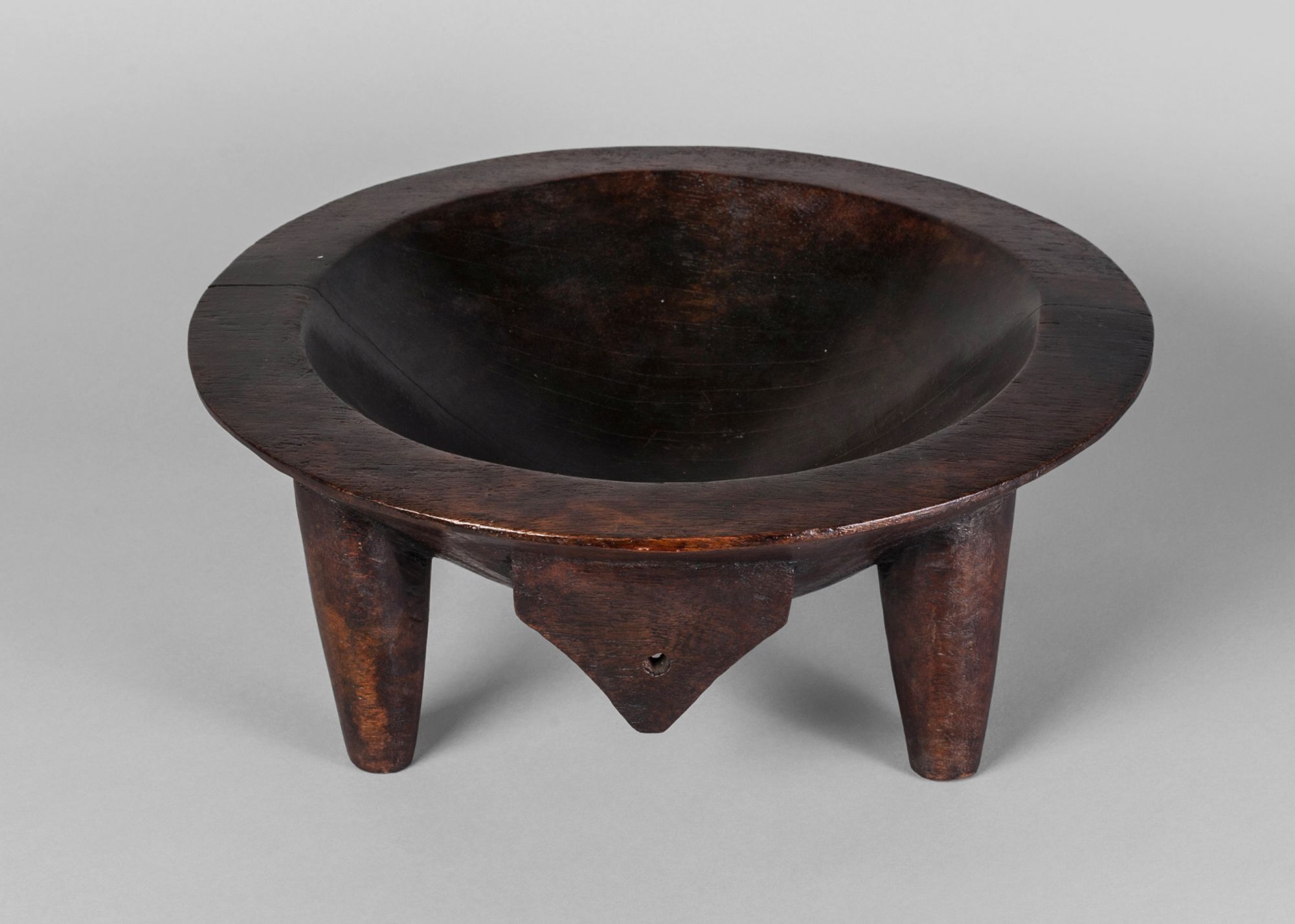 A Fijian hardwood yaqona bowl, 20th century, on four legs with a hanging hook,