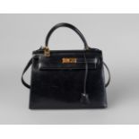 A Hermes black leather Kelly bag, with gold plated hardware, detachable shoulder strap,