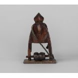 A Tribal hardwood heddle pully, Senoufo, Ivory Coast, mounted on a metal base,