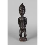 A tribal hardwood figure of a man, Ivory Coast, Baule,