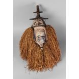 A Yaka tribal mask, with a tiered disk top, the face carved with long big nose and oval eyes,