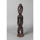 A tribal hardwood figure of a man, Ivory Coast, Baule,