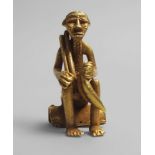 An African tribal gold figure of a seated man with a plantain, Ivory Coast, early/mid 20th century,