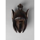 A Yaure elephant mask, with elongated ears and tusks, with a bird to the top,