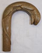 A carved wooden walking stick top in the form of a lizard