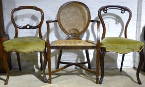 A caned armchair and two others