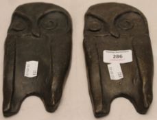 A pair of bronze plaques depicting owls