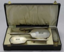 A cased silver dressing table set