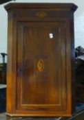 A George III inlaid mahogany corner cupboard