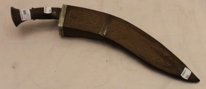 A carved wooden sheathed kukri