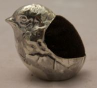 A silver pin cushion in the form of a chick