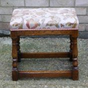 An upholstered oak stool