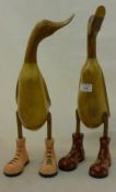 Two wooden ducks wearing boots