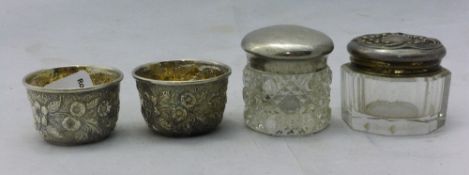 Two small silver top jars and a pair of salts