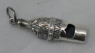 A silver whistle in the form of a dog