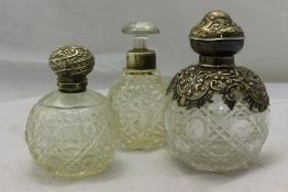 Three silver top perfume bottles