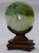 A jade disc on a wooden stand