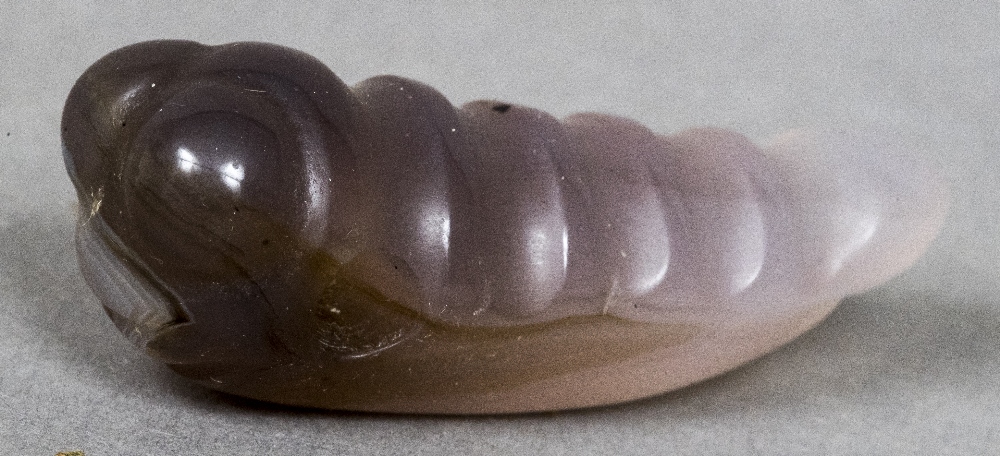 A Chinese carved jade model of a grub With hole drilled behind the head. 4.75 cm long.