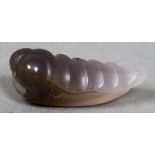 A Chinese carved jade model of a grub With hole drilled behind the head. 4.75 cm long.