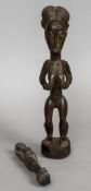 An Ivory Coast carved wooden figure of a woman Modelled holding her breasts;