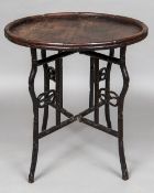 A 19th century Chinese hardwood folding occasional table The circular top with faux bamboo gallery,