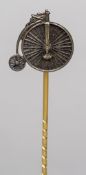 An unmarked white and yellow metal stick pin The head formed as a penny farthing,